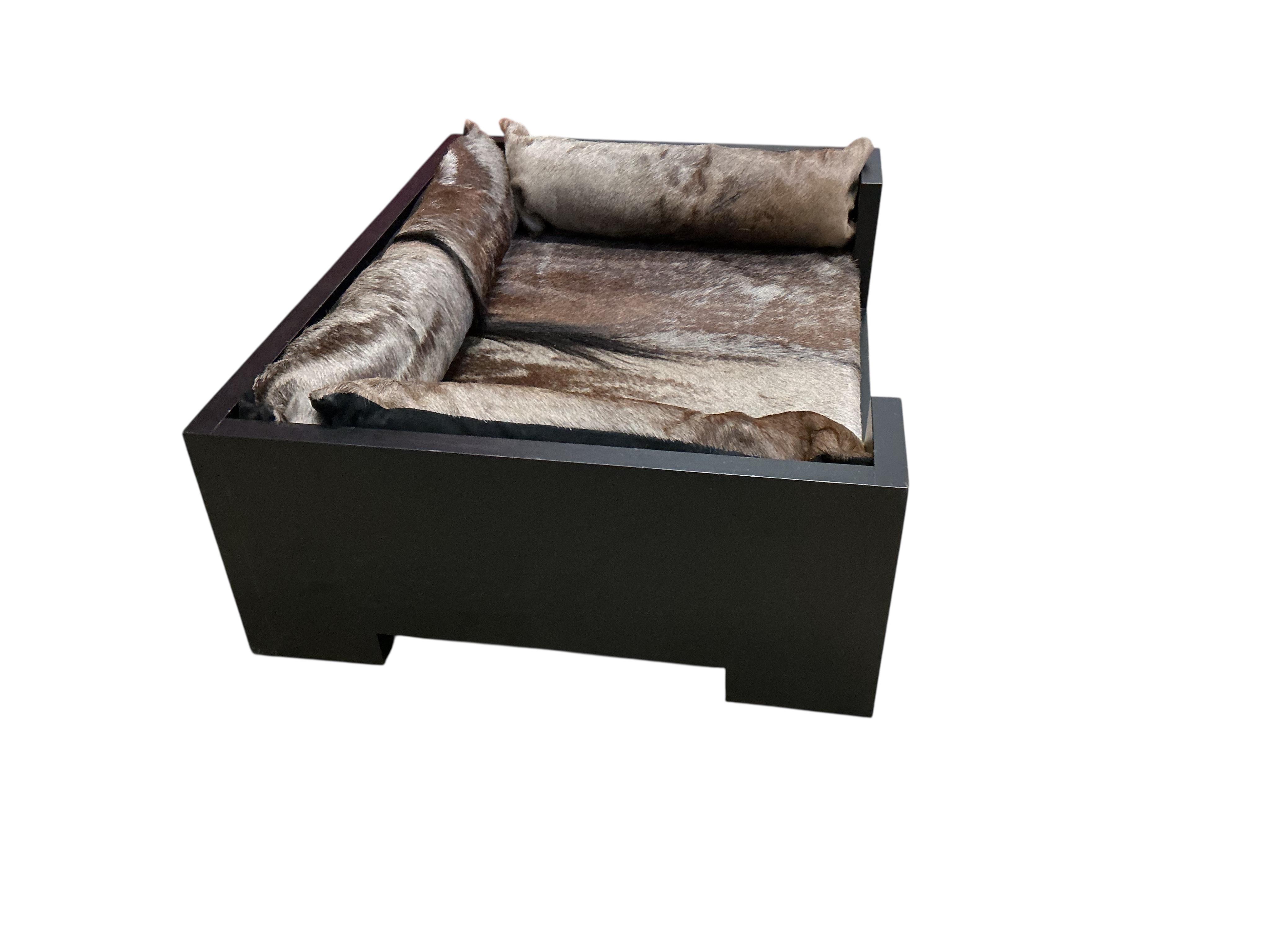A contemporary ebonised dog bed with faux fur cushions, width 87cm, depth 67cm, height 29cm